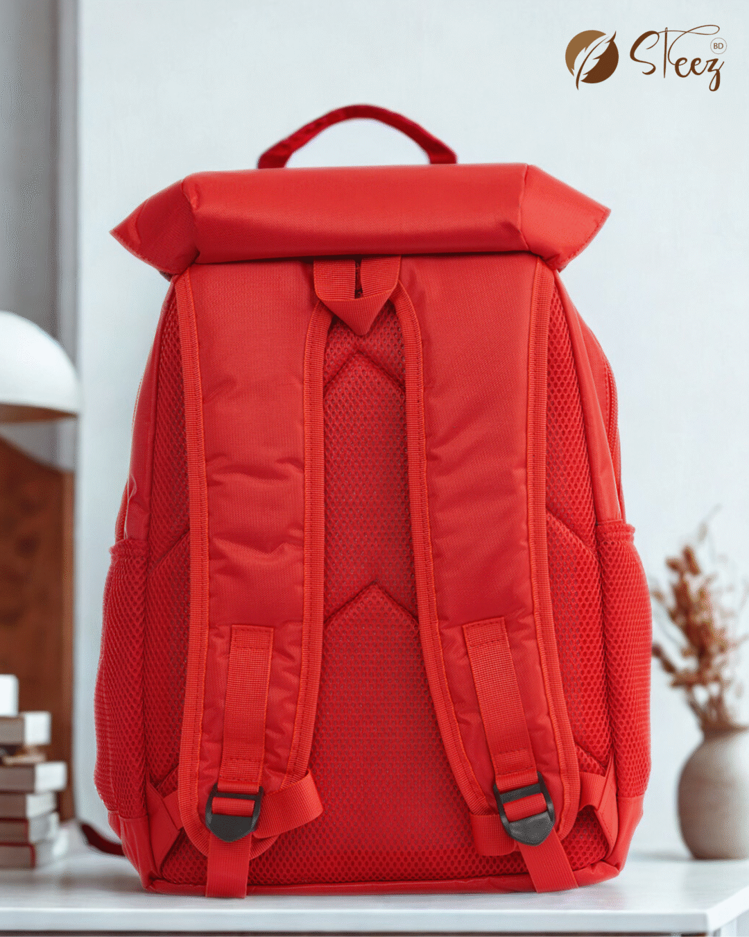 Bright red waterproof backpack with flap top buckle closure and side mesh pockets against a neutral background.